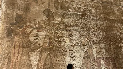 Aswan, Egypt - Feb 8, 2025: Ancient relief at Abu Simbel showing Pharaoh with priests presenting offerings and a sacred barque in a temple ritual.