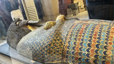 Cairo, Egypt -  Feb 4, 2025: Gilded coffin from KV55 with defaced face and cartouche, likely belonging to Akhenaten, displayed at the Egyptian Museum of Antiquities in Cairo.