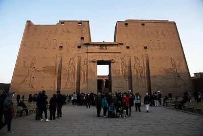 Tourists explore the Temple of Edfu at dawn, bath