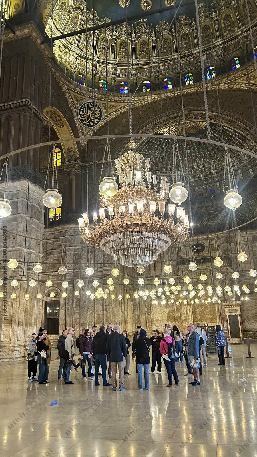 Cairo, Egypt - Feb 6, 2025: People admiring the interior of the Muhammad Ali mosque (or Alabaster mosque) with its beautiful lighting and chandelier in the citadel of Cairo, Egypt
