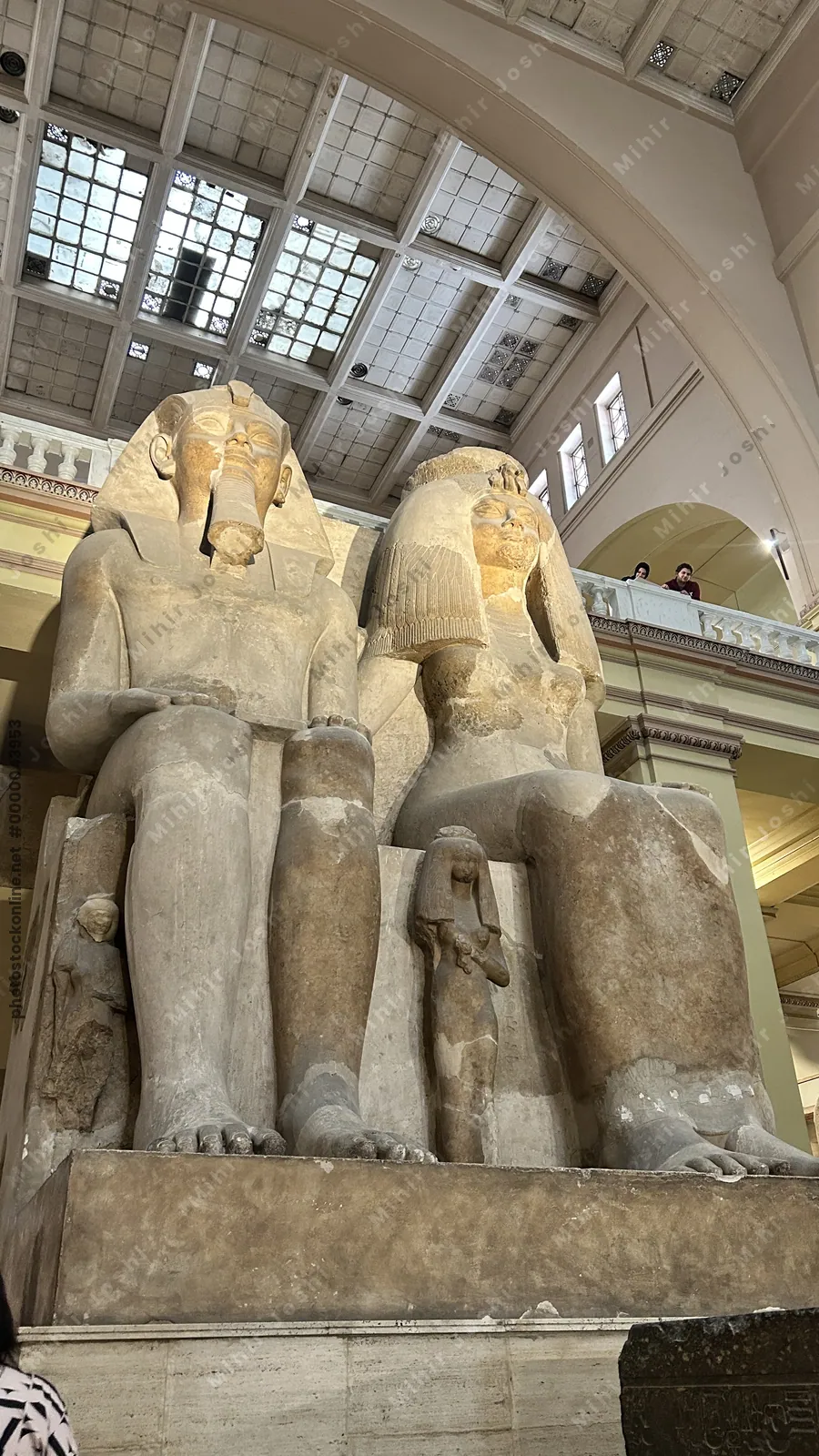 Cairo, Egypt -  Feb 4, 2025: Massive seated statue of Pharaoh Amenhotep III with Queen Tiye and daughters, symbolizing royal power and family, displayed at the Egyptian Museum in Cairo.