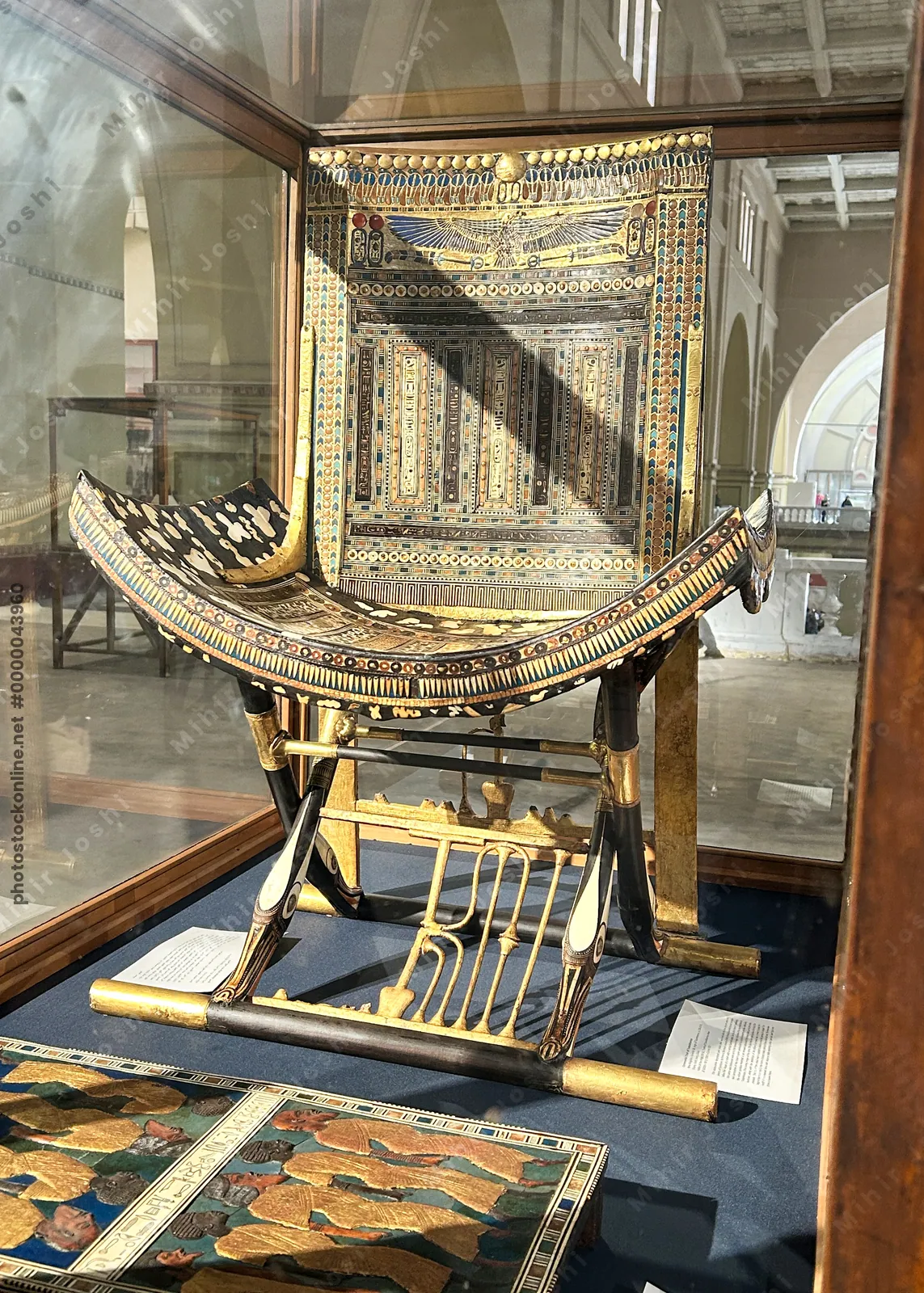 Cairo, Egypt -  Feb 4, 2025: Gilded ceremonial throne of Tutankhamun, richly decorated with colored inlays, displayed at the Egyptian Museum in Cairo, Egypt.
