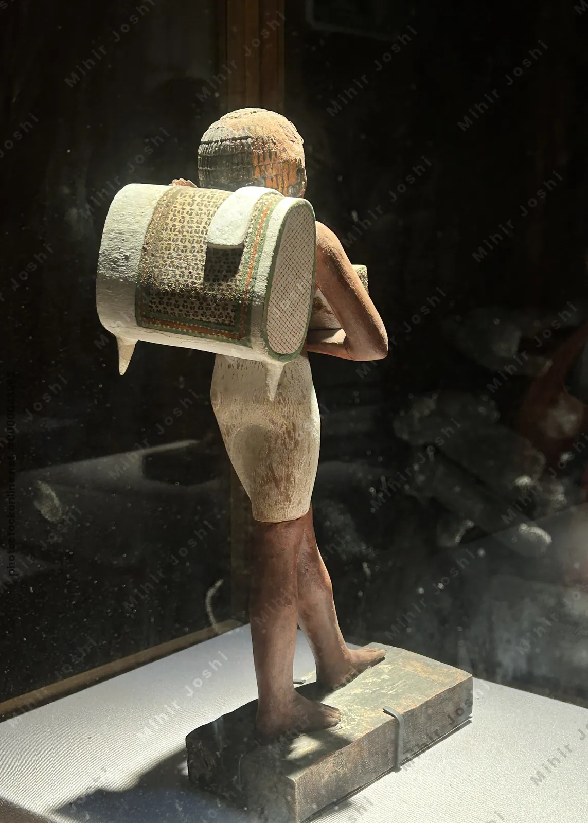 Cairo, Egypt -  Feb 4, 2025: Striding statue of the porter, Niankhpepikem, carrying a back pack and a basket.