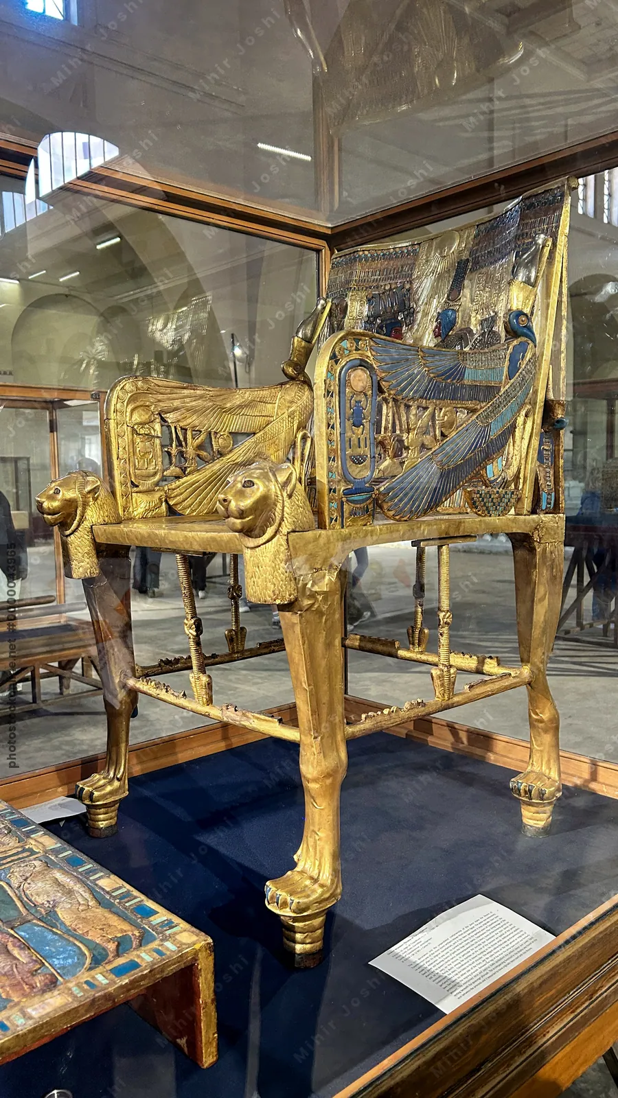 Cairo, Egypt -  Feb 4, 2025: Elaborately decorated golden throne of Pharaoh Tutankhamun with inlays and intimate royal scene, displayed at the Egyptian Museum in Cairo.