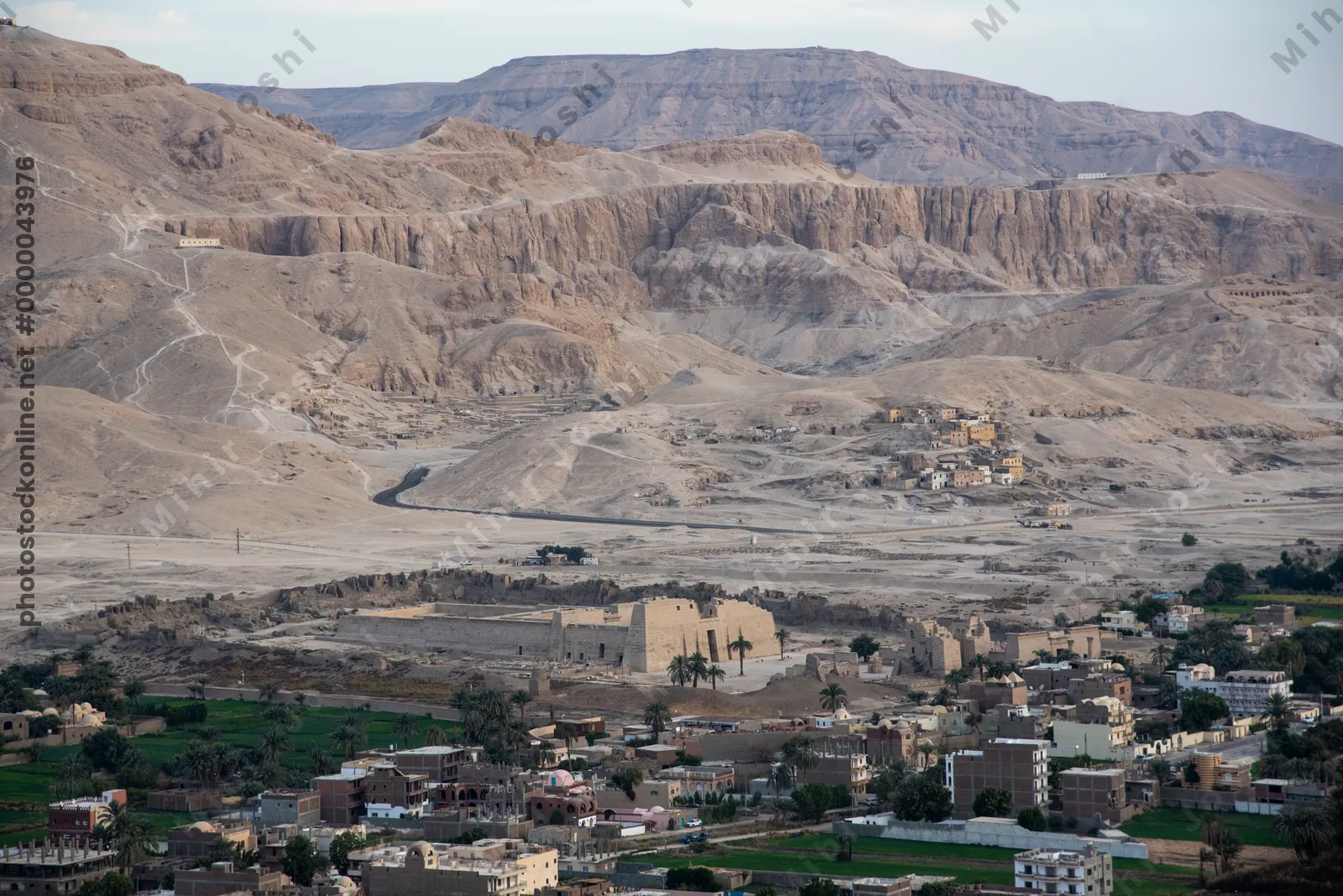 Luxor, Egypt - Feb 10, 2025: Hot air balloon ride over Luxor with aerial view of Medinet Habu temple and distant mountains in the soft morning light
