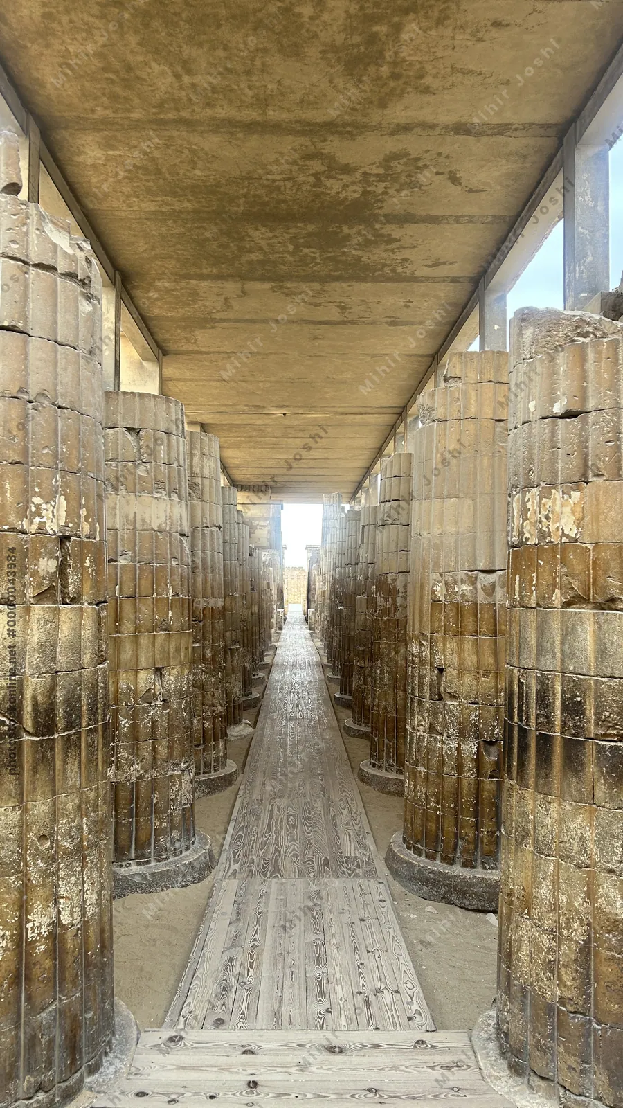 Saqqara, Egypt - Feb 5, 2024: Stone columns flanking the entrance corridor to the Step Pyramid of Djoser at Saqqara