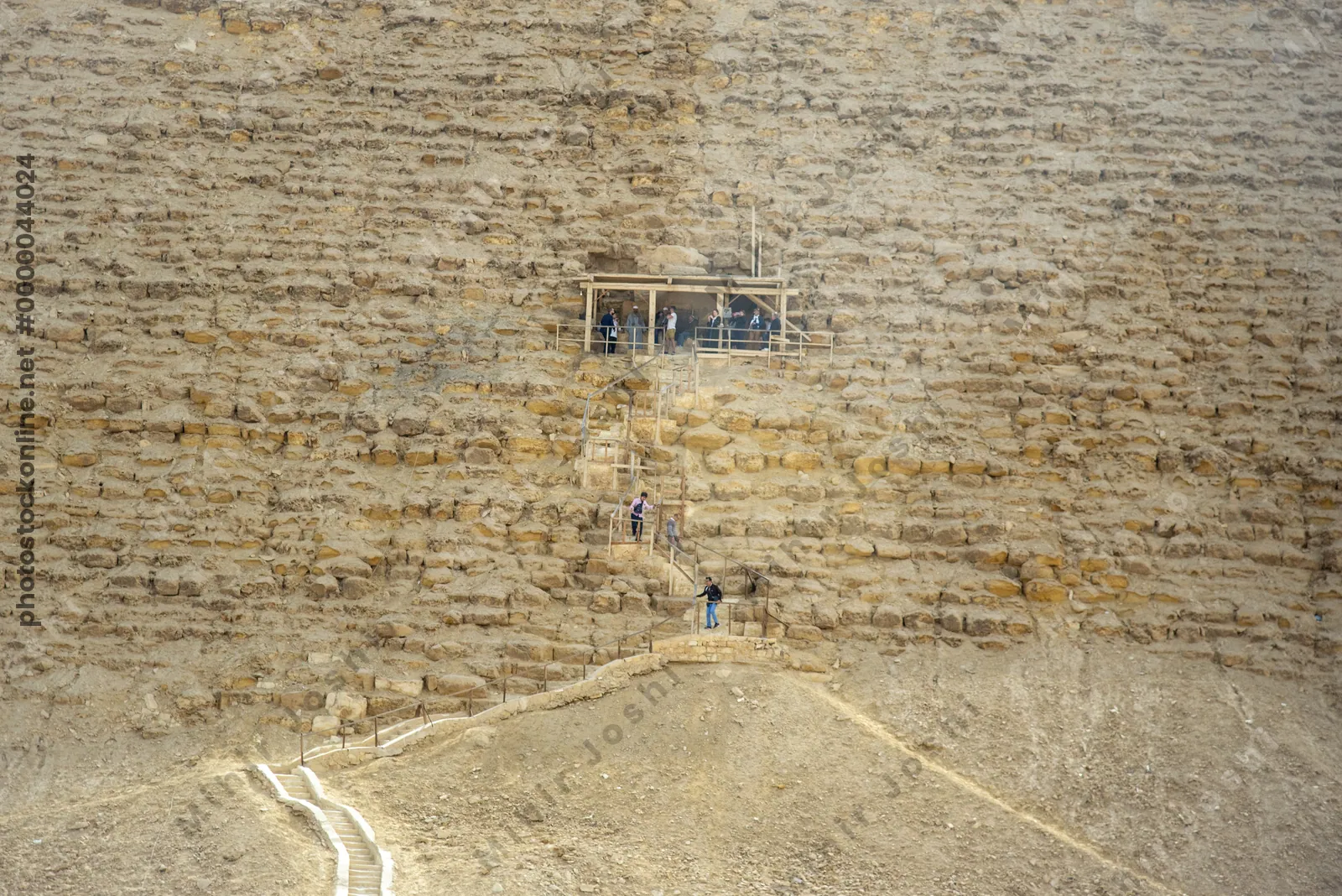 Dahshur, Egypt - Feb 5, 2024: Tourists ascend stairs to reach the elevated entrance of the Red Pyramid at Dahshur, built by Pharaoh Sneferu during Old Kingdom.