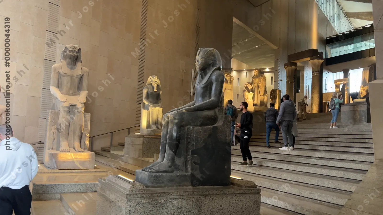 Giza, Egypt - Feb 6, 2025: Video of the Grand Egyptian Museum’s first staircase section, showcasing seated statues and figures in a vertical sculpture gallery.
