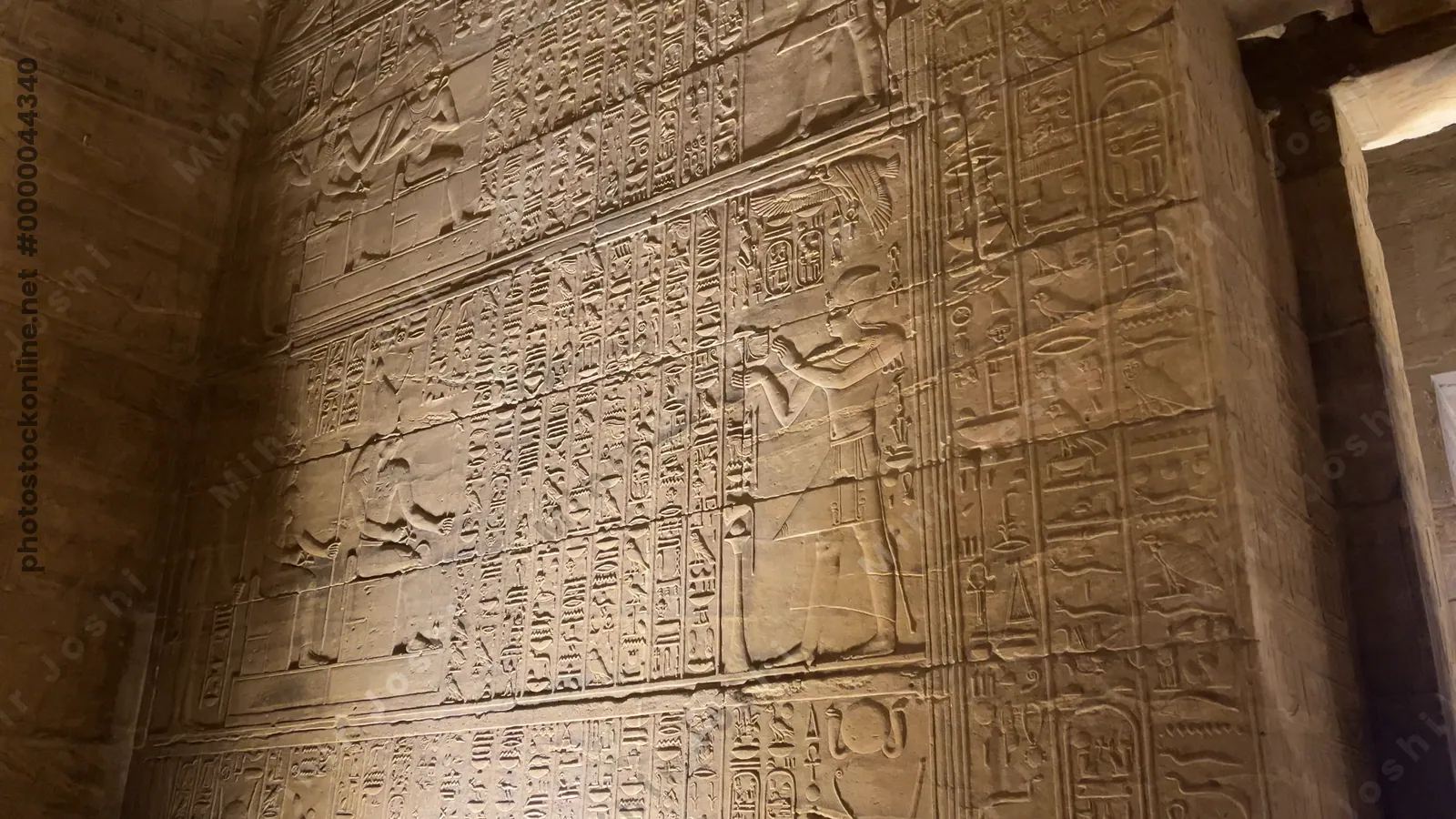 Agilkia, Egypt - Feb 7, 2024: Wall at the Temple of Philae in Aswan, Egypt, with detailed reliefs depicting ancient Egyptian gods and goddesses in stone carvings.