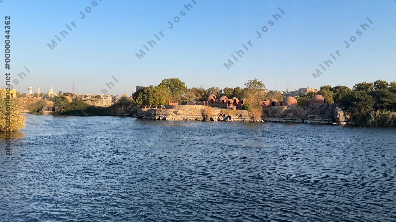 Aswan, Egypt - Feb 7, 2024: Serene boat ride on the historic Old Cataract stretch of the Nile River in Aswan, Egypt, surrounded by desert and river scenery.