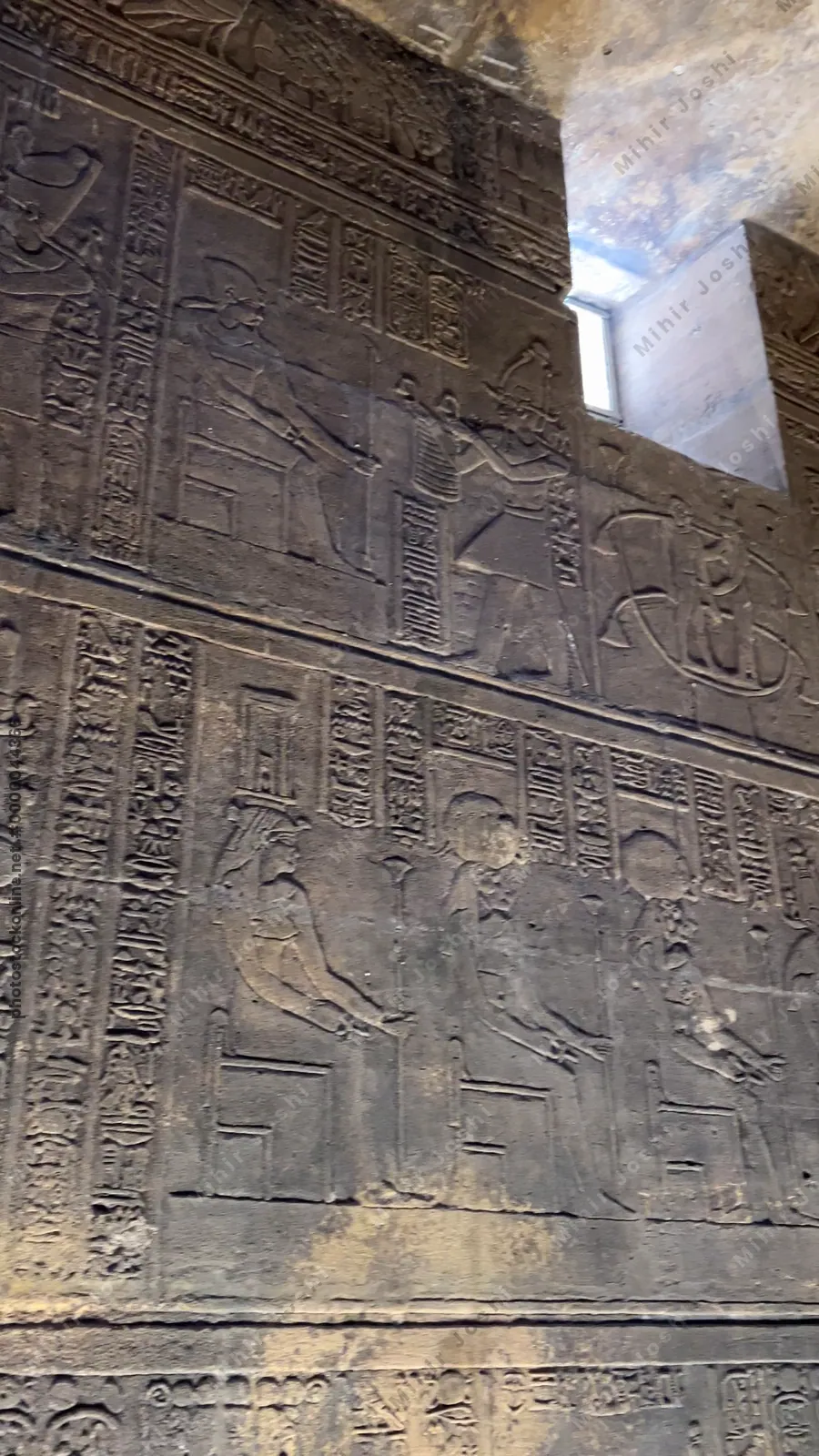 Agilkia, Egypt - Feb 7, 2024: Wall at the Temple of Philae in Aswan, Egypt, with detailed reliefs depicting ancient Egyptian gods and goddesses in stone carvings.