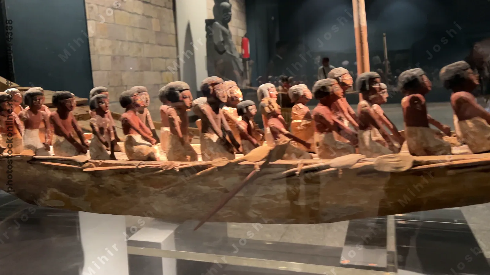 Luxor, Egypt - Feb 9, 2025: Wooden funerary boat model with painted rower figurines from ancient Egypt, displayed in the Luxor Museum as part of its archaeological collection.