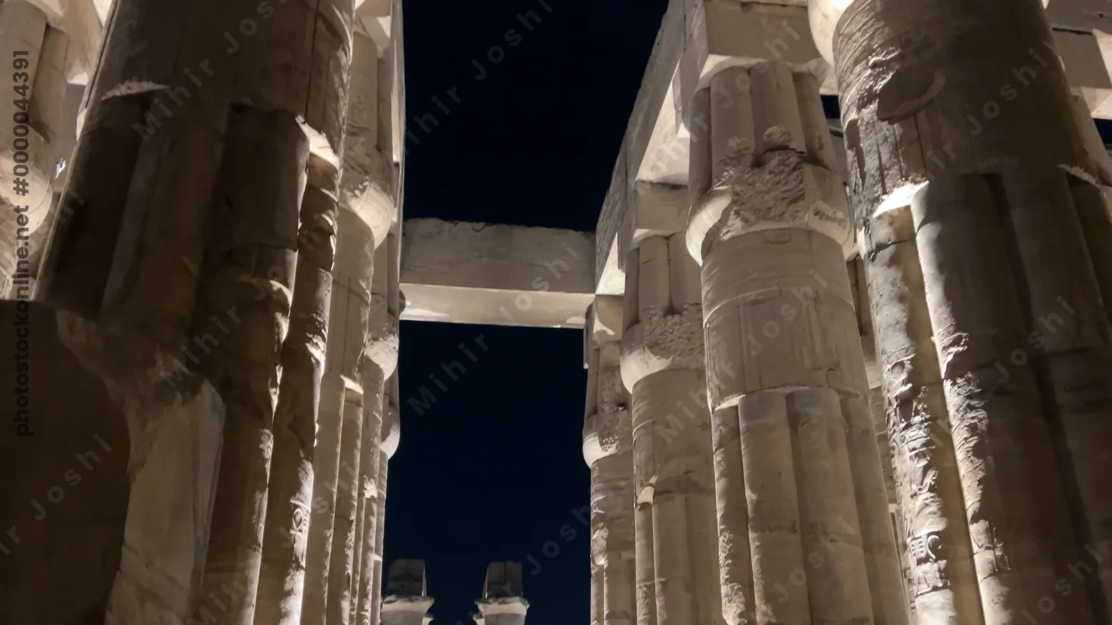 Luxor, Egypt - Feb 9, 2025: Footage of the illuminated hypostyle hall columns of Luxor Temple at night in Egypt, showing massive sandstone pillars against the dark sky.