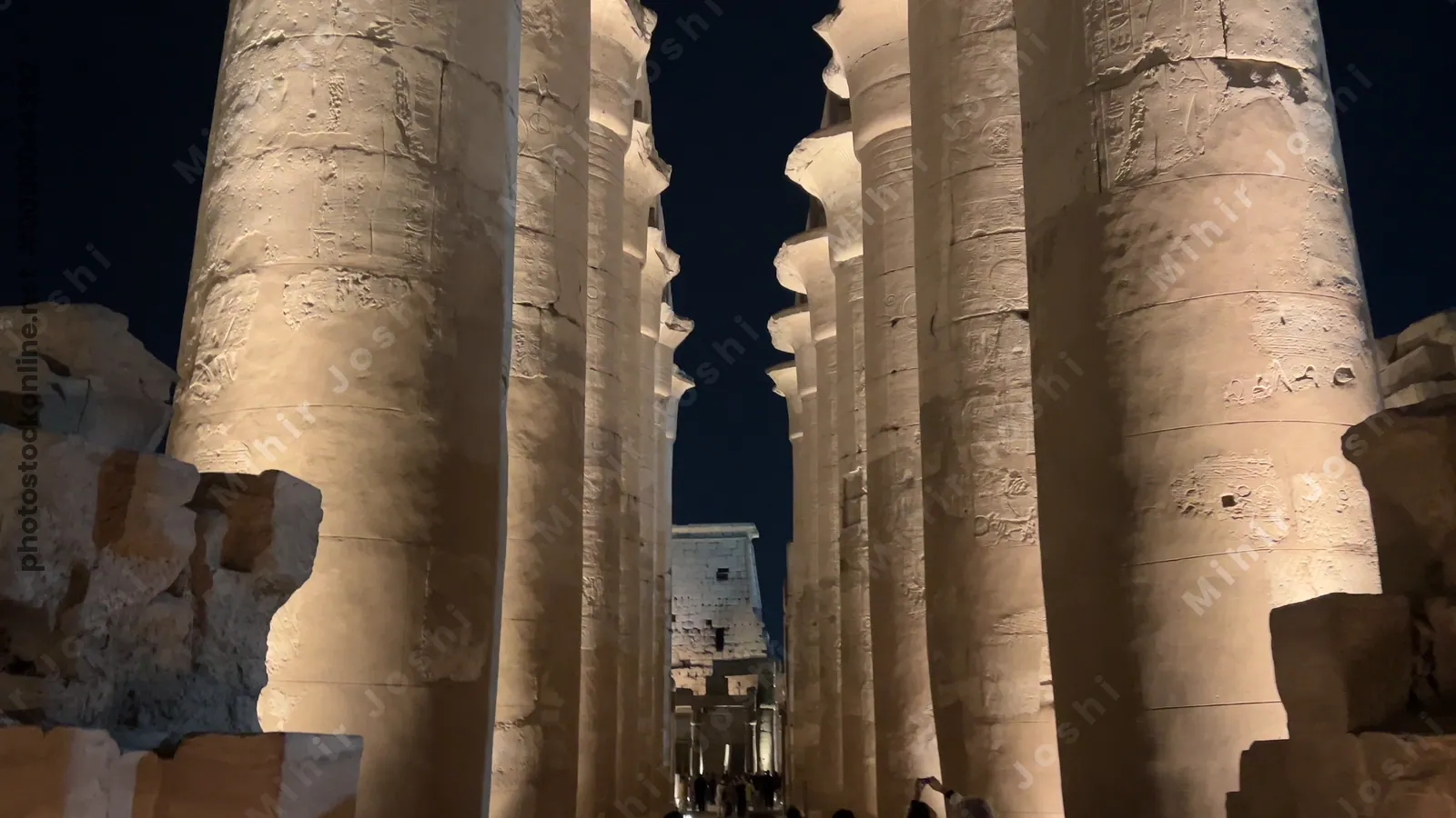 Luxor, Egypt - Feb 9, 2025: Footage of the illuminated hypostyle hall columns of Luxor Temple at night in Egypt, showing massive sandstone pillars against the dark sky.