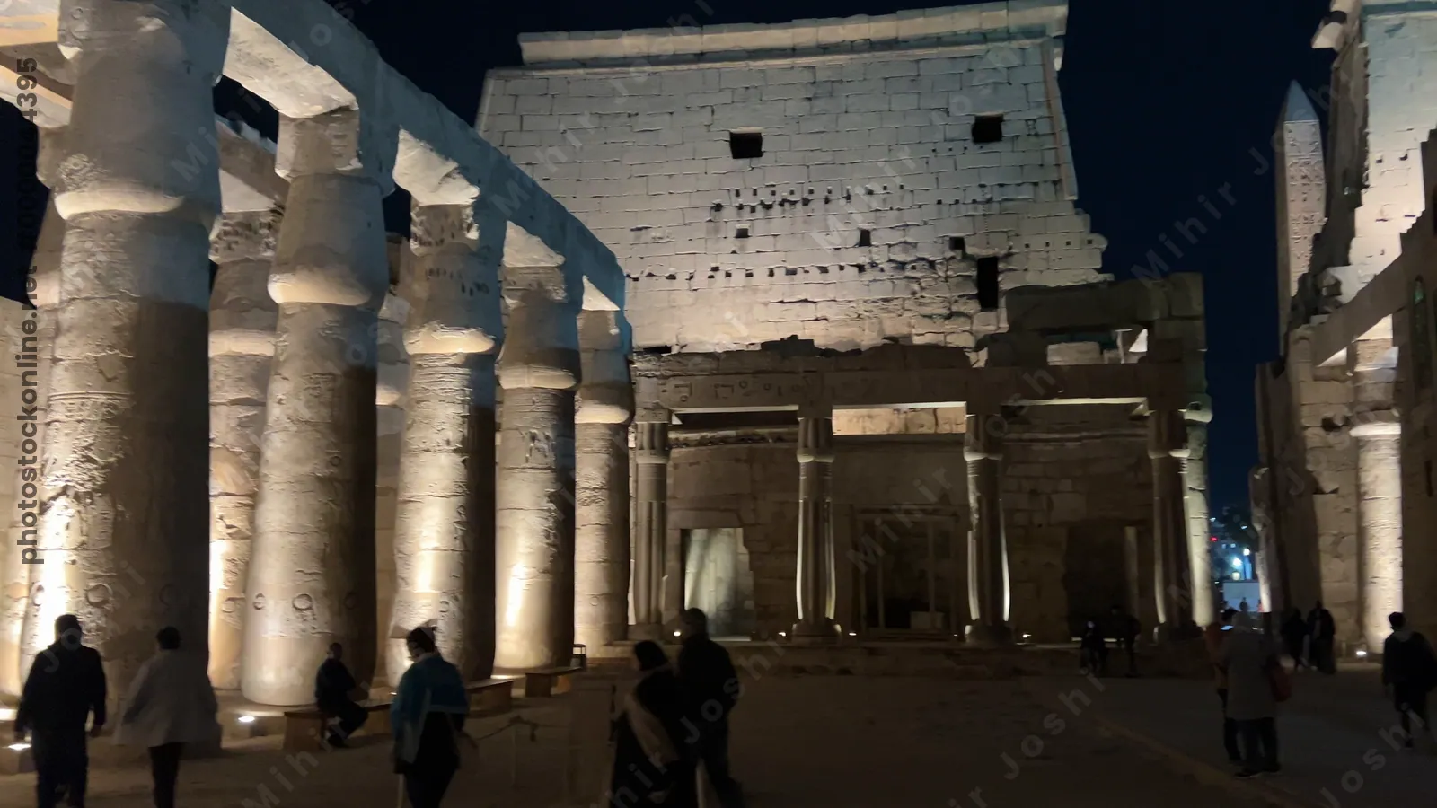 Luxor, Egypt - Feb 9, 2025: Footage of Luxor Temple at night in Egypt, showing illuminated colossal statues, stone columns, entrance pylons, and the mosque built above the ancient site.