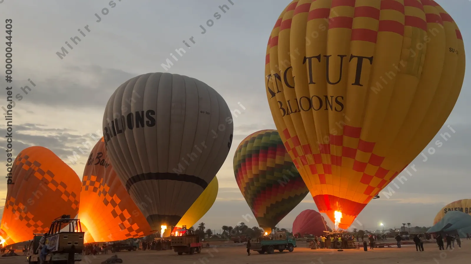 Luxor, Egypt - Feb 10, 2025: Colorful hot air balloons being inflated at dawn, preparing for a sunrise flight over the Nile Valley.