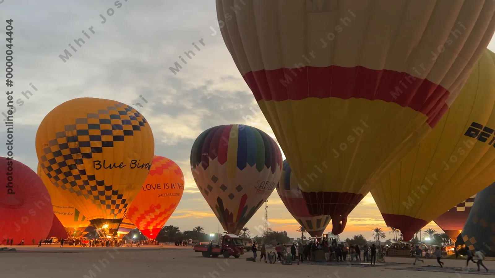 Luxor, Egypt - Feb 10, 2025: Colorful hot air balloons being inflated at dawn, preparing for a sunrise flight over the Nile Valley.