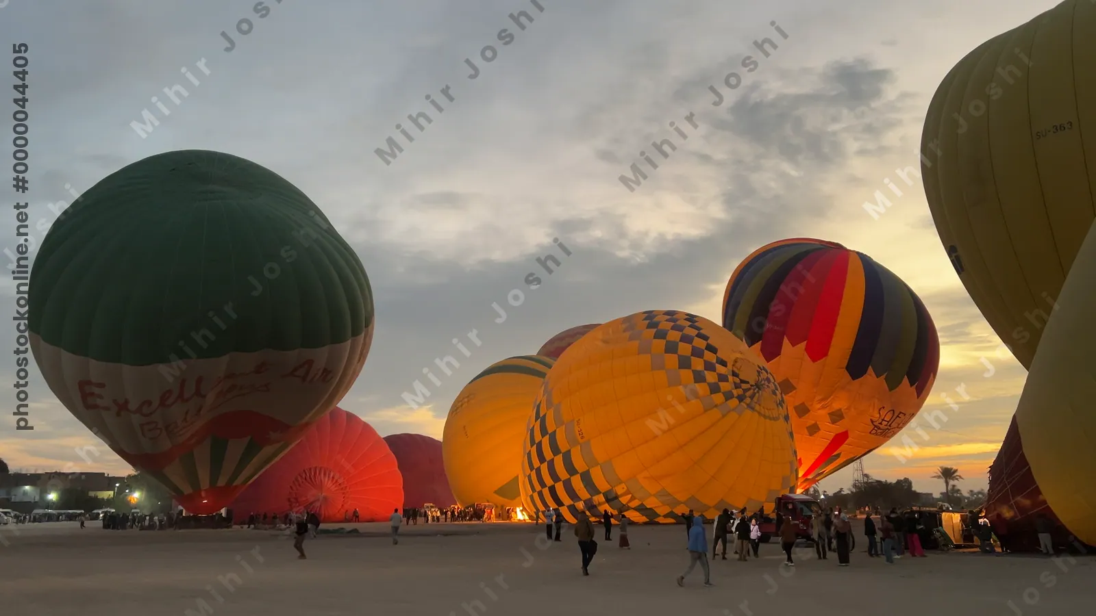 Luxor, Egypt - Feb 10, 2025: Colorful hot air balloons being inflated at dawn, preparing for a sunrise flight over the Nile Valley.