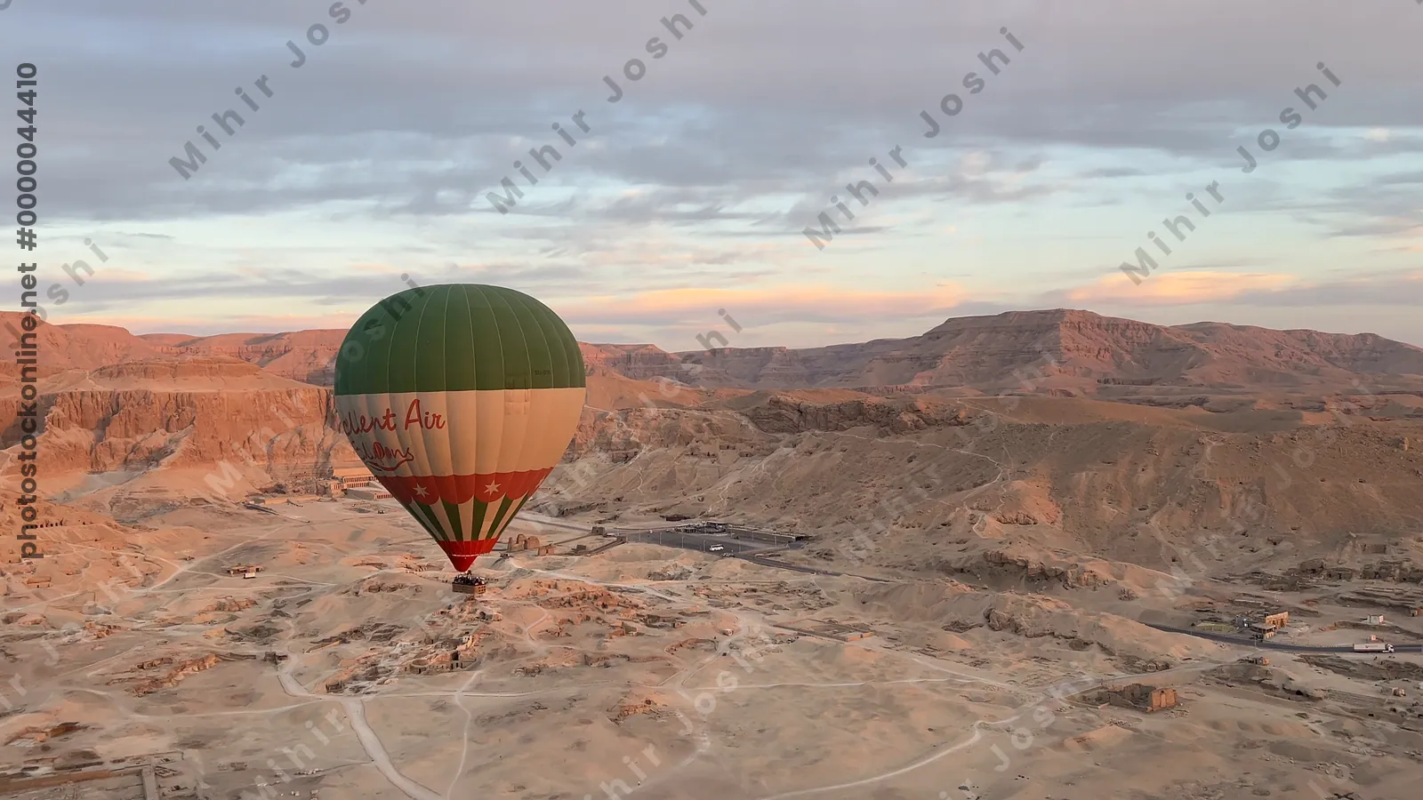 Luxor, Egypt - Feb 10, 2025: Hot air balloon floating above desert mountains and ancient ruins near Luxor, offering a scenic aerial perspective.
