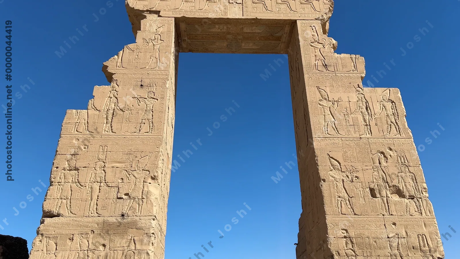 Dendera, Egypt - Feb 10, 2025: Footage of the monumental stone gateway leading to the Temple of Dendera, decorated with carvings and hieroglyphs in Egypt.