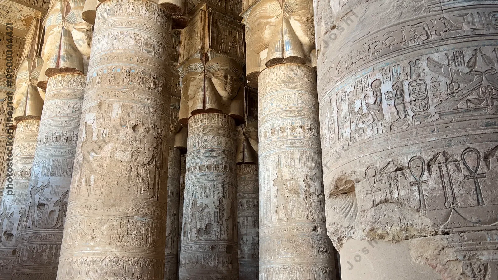 Dendera, Egypt - Feb 10, 2025: Tracking footage walking through massive stone columns decorated with carvings and hieroglyphs inside the Temple of Dendera in Egypt.