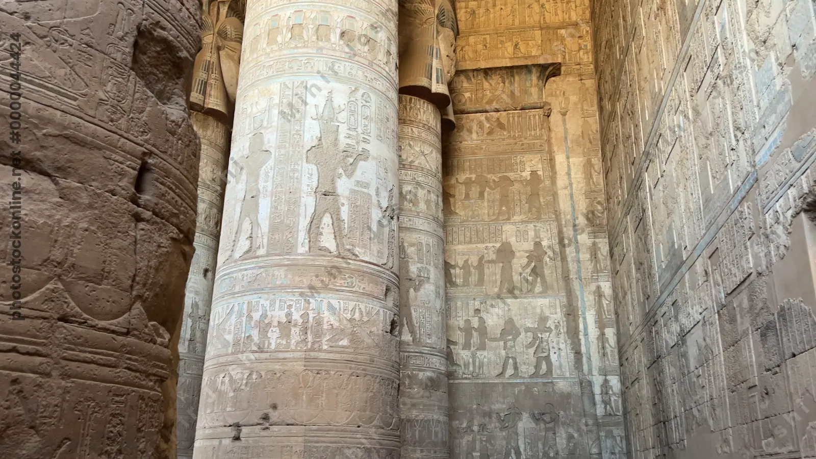 Dendera, Egypt - Feb 10, 2025: Tracking footage walking through massive stone columns decorated with carvings and hieroglyphs inside the Temple of Dendera in Egypt.