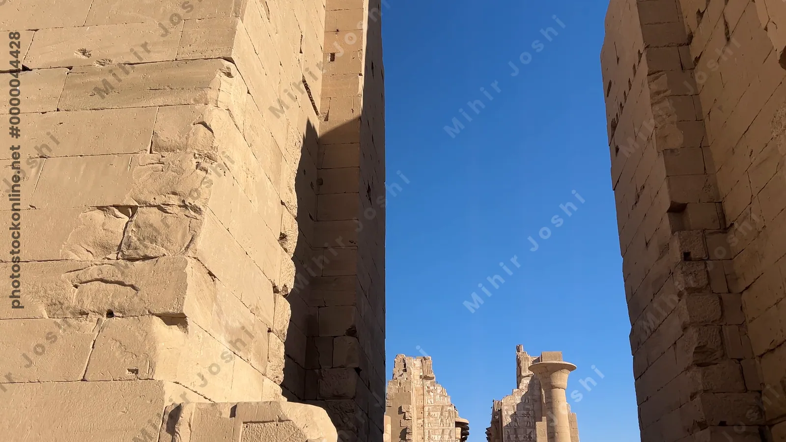Luxor, Egypt - Feb 10, 2025: Tourists walking through the monumental entrance into Karnak Temple in Luxor, Egypt, one of the largest temple complexes in the world.