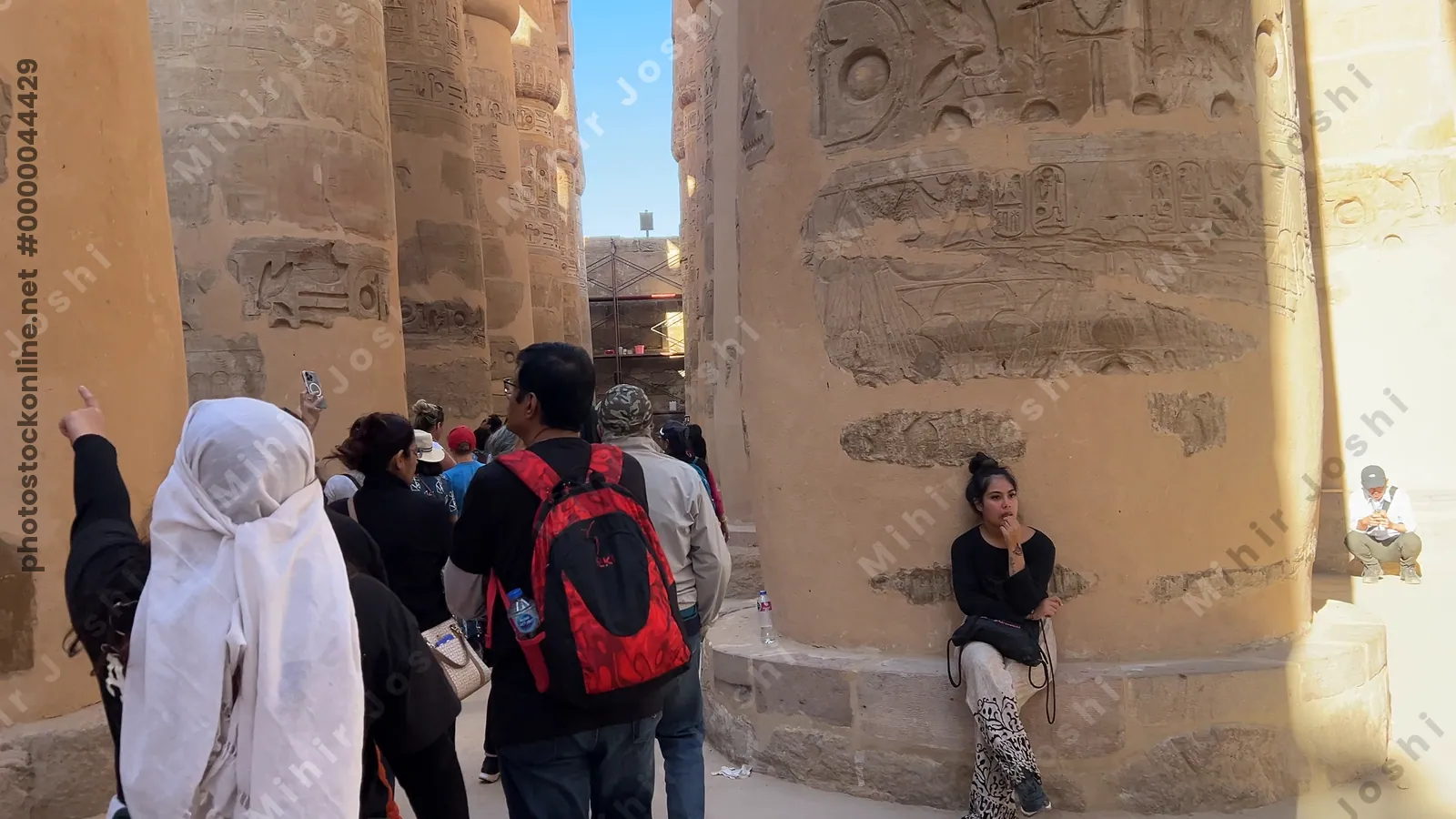 Luxor, Egypt - Feb 10, 2025: Tourists walking through the massive sandstone columns of the Hypostyle Hall inside Karnak Temple in Luxor, Egypt.
