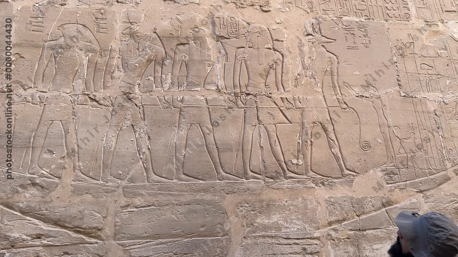 Luxor, Egypt - Feb 10, 2025: Ancient carved wall relief depicting a processional barque with gods and figures at Karnak Temple in Luxor, Egypt.
