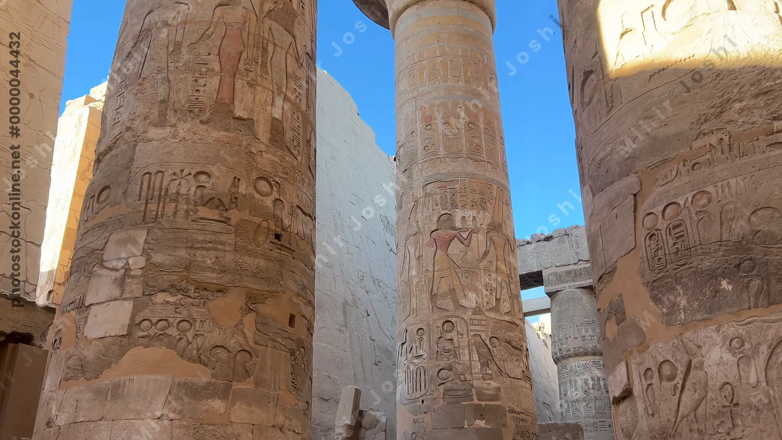 Luxor, Egypt - Feb 10, 2025: Tourists exploring the Hypostyle Hall of Karnak Temple, surrounded by towering sandstone columns decorated with hieroglyphs and relief carvings.