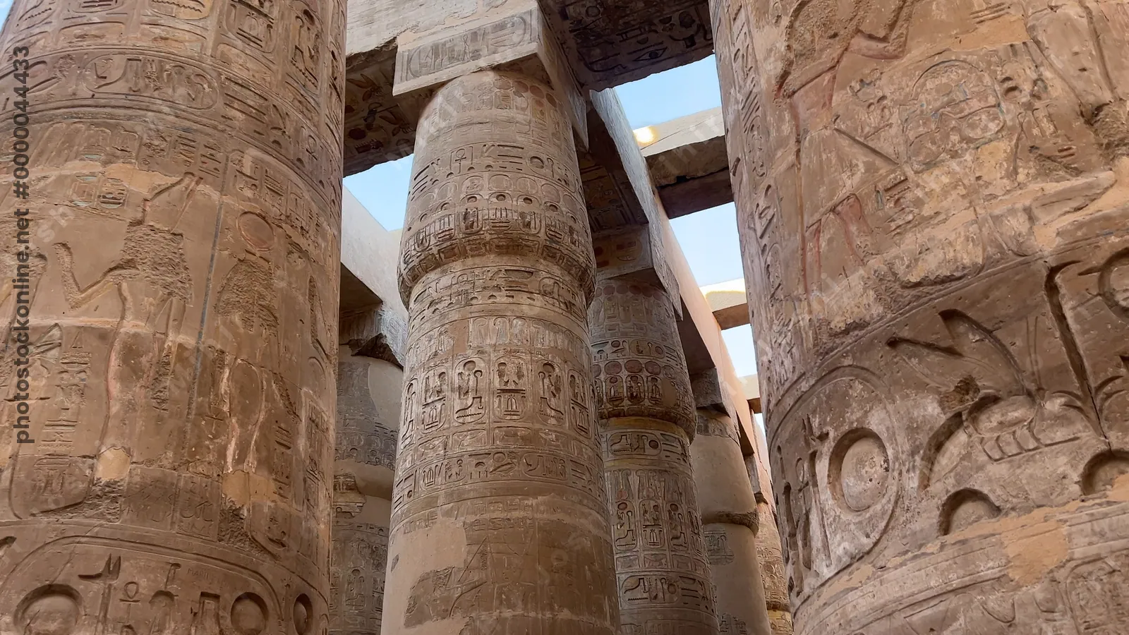 Luxor, Egypt - Feb 10, 2025: Tourists exploring the Hypostyle Hall of Karnak Temple, surrounded by towering sandstone columns decorated with hieroglyphs and relief carvings.