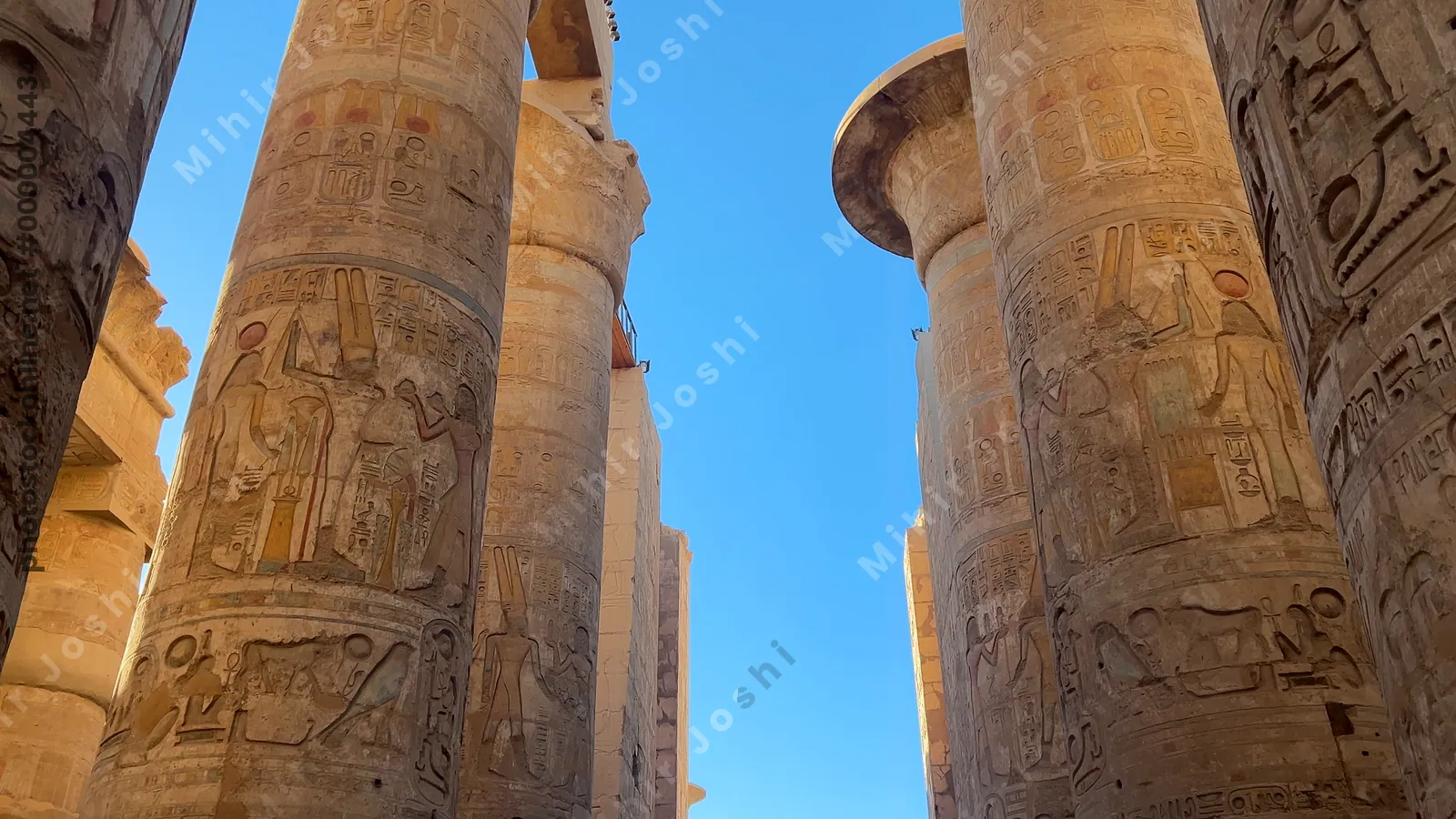 Luxor, Egypt - Feb 10, 2025: Tourists exploring the Hypostyle Hall of Karnak Temple, surrounded by towering sandstone columns decorated with hieroglyphs and relief carvings.