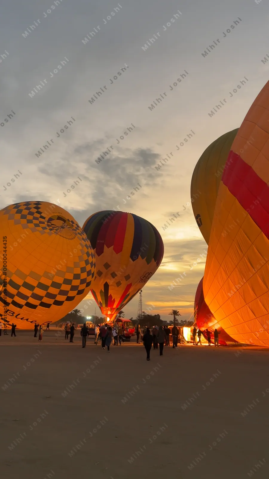 Luxor, Egypt - Feb 10, 2025: Colorful hot air balloons being inflated at dawn, preparing for a sunrise flight over the Nile Valley.