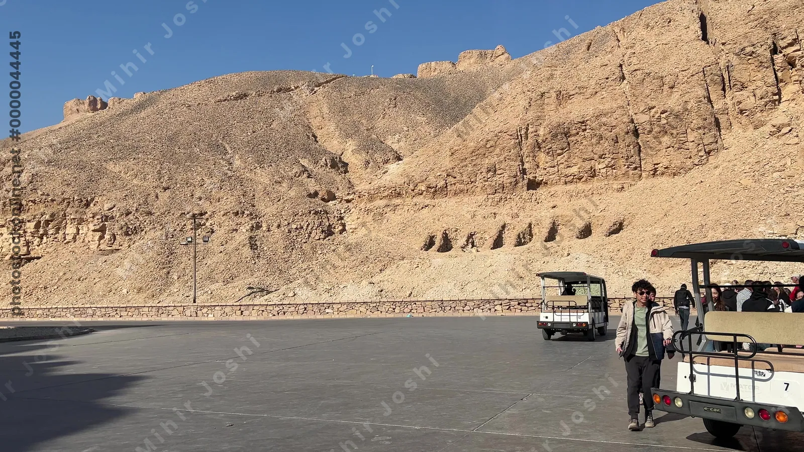 Luxor, Egypt - Feb 11, 2025: Electric shuttle cars transporting tourists to the tomb entrances at the Valley of the Kings heritage site.