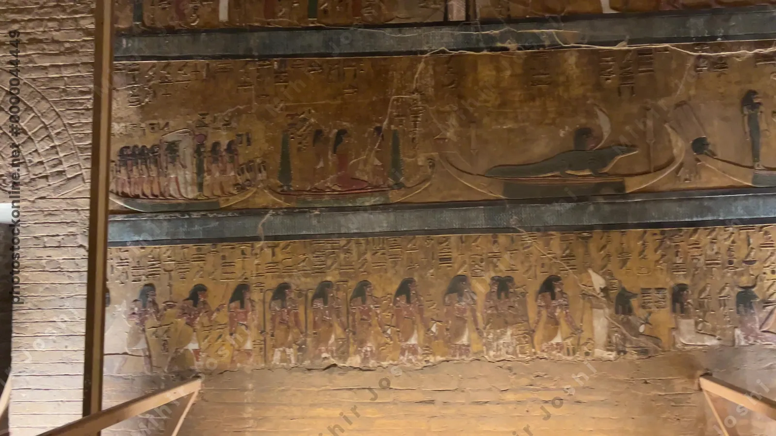 Valley of the Kings, Egypt - Feb 11, 2025: Ancient Egyptian wall relief showing the solar barque with deities and hieroglyphics inside the Tomb of Seti I.