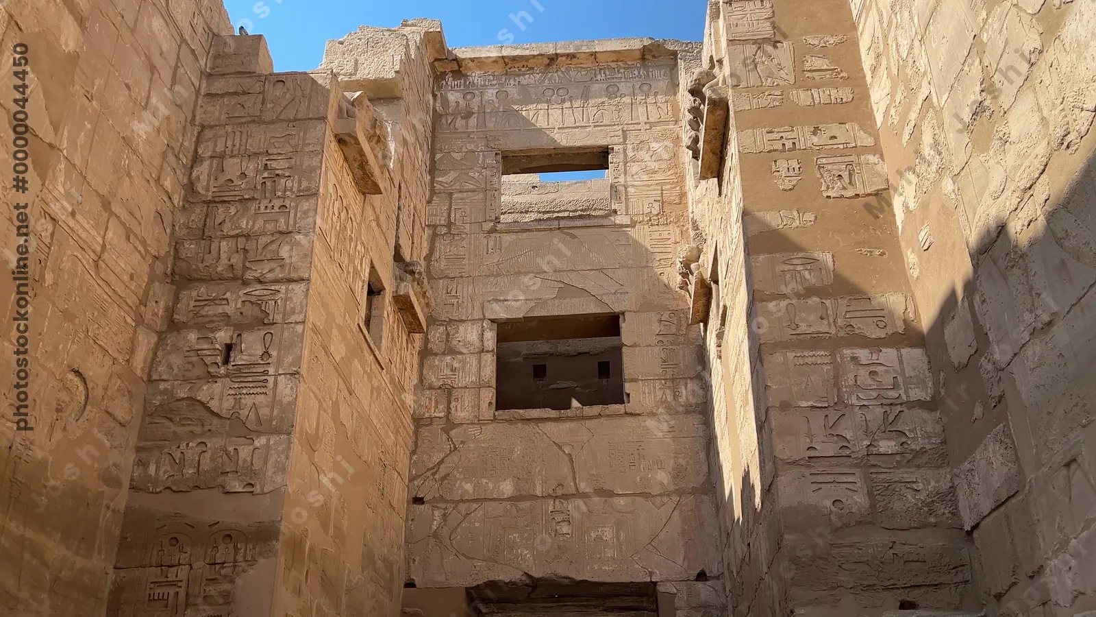 Luxor, Egypt - Feb 11, 2025: Ancient stone gateway with hieroglyphic carvings at the Migdol Gate of the Mortuary Temple of Ramesses III in Medinet Habu, Luxor, Egypt.