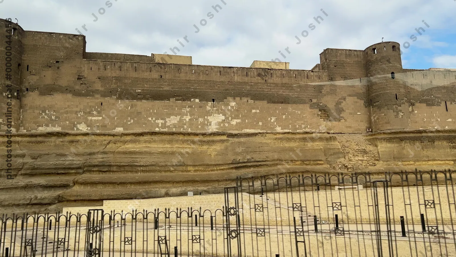 Cairo, Egypt - Feb 12, 2025: Stone walls and towers of the Citadel of Cairo, a medieval Islamic fortress and UNESCO heritage site, viewed while traveling by bus.