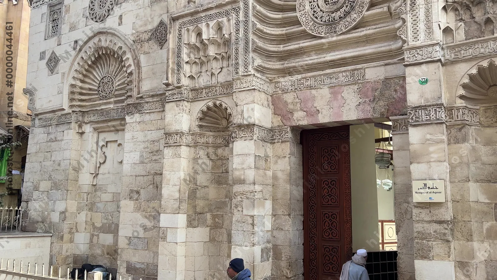Cairo, Egypt - Feb 12, 2025: The ornate stone facade of the historic Aqmar Mosque on al-Mu'izz Street in Cairo, Egypt, featuring detailed Islamic calligraphy and carvings.
