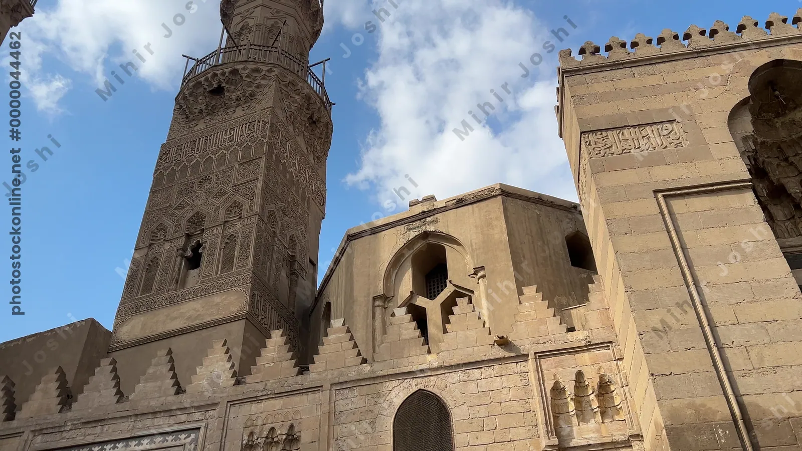 Cairo, Egypt - Feb 12, 2025: The ornate stone facade of the historic Aqmar Mosque on al-Mu'izz Street in Cairo, Egypt, featuring detailed Islamic calligraphy and carvings.