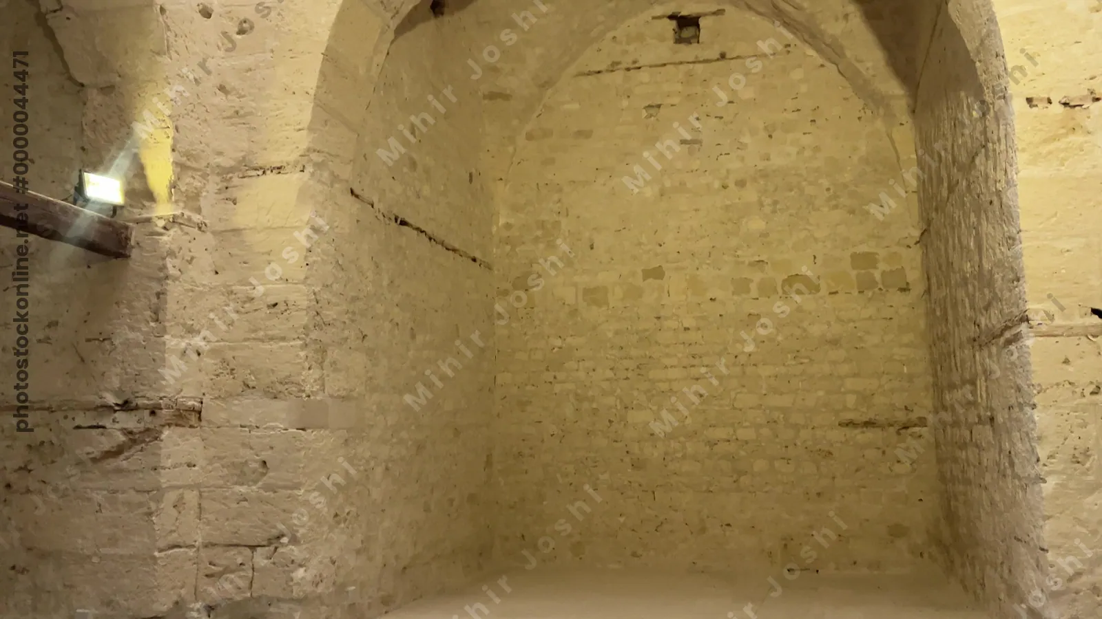 Alexandria, Egypt - Feb 13, 2025: Interior of mosque at the Citadel of Qaitbay featuring ornate marble floor patterns, stone walls, and barred windows of the medieval fortress.
