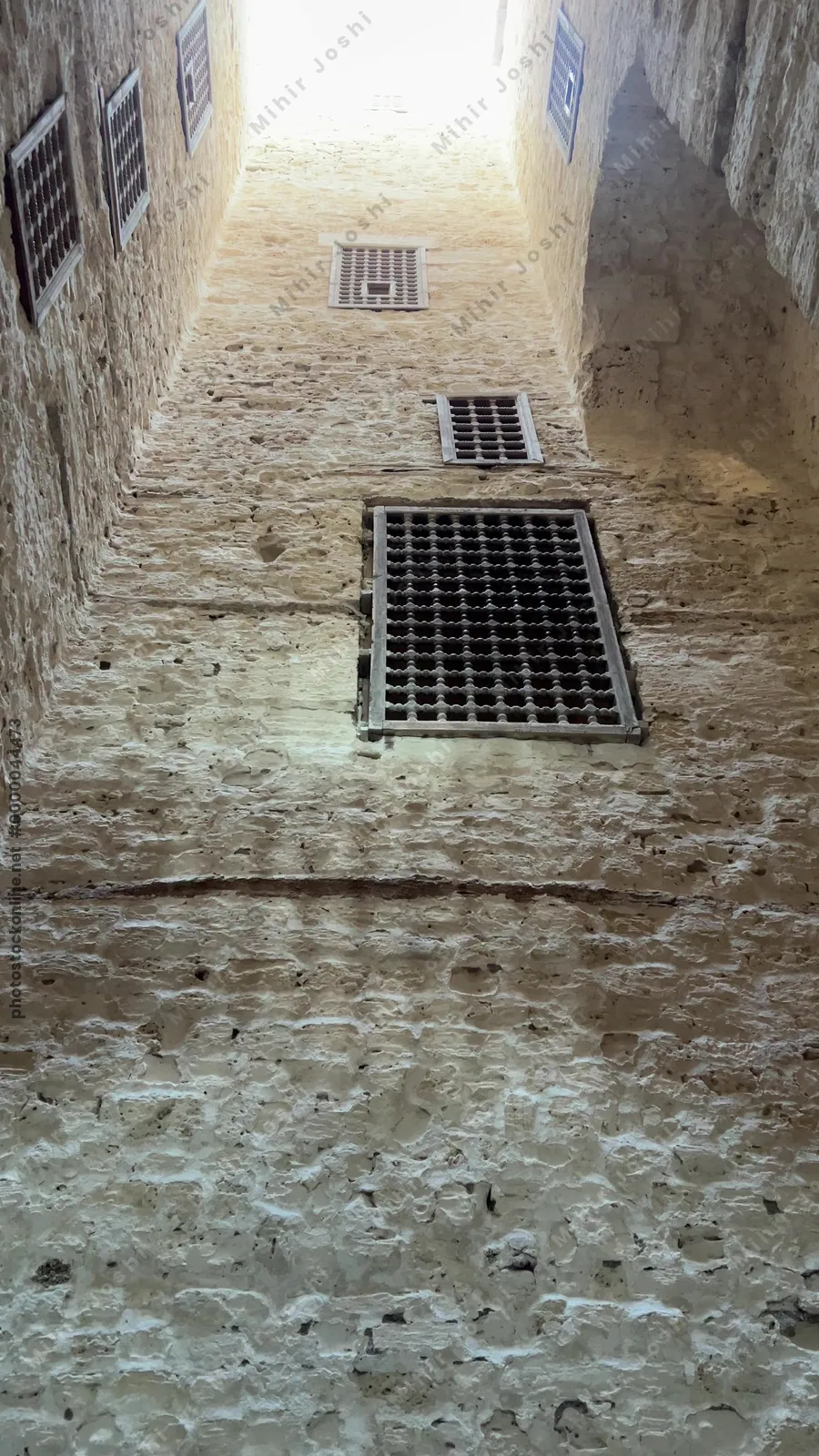 Alexandria, Egypt - Feb 13, 2025: Bottom-up view of interior tower walls with barred windows at the Citadel of Qaitbay, a medieval fortress and historic landmark.