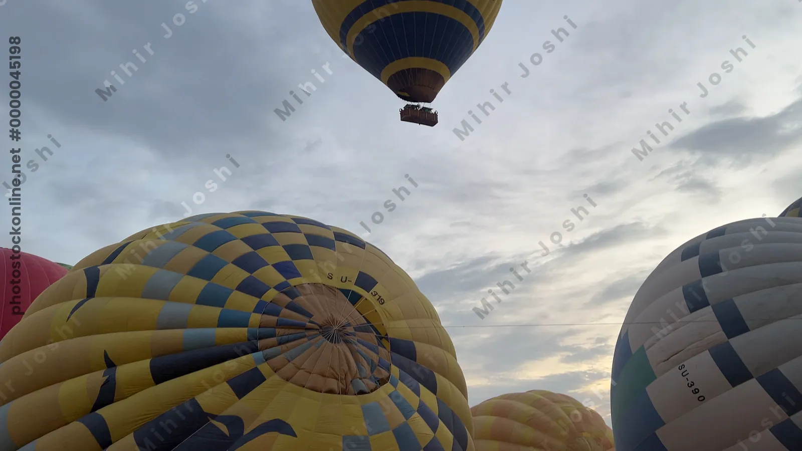 Luxor, Egypt - Feb 10, 2025: Colorful hot air balloons drifting above lush green fields at sunrise, offering a scenic aerial view of the landscape.