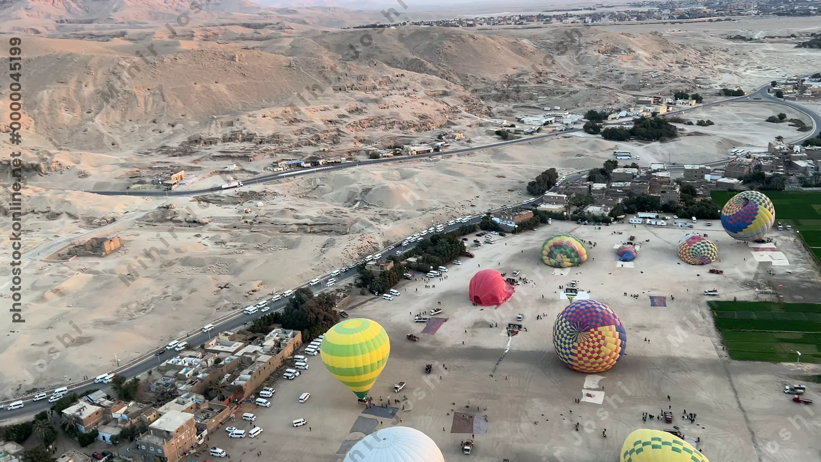 Luxor, Egypt - Feb 10, 2025: Aerial footage from a hot air balloon ride showing colorful balloons and desert landscape around Luxor on the west bank of the Nile.