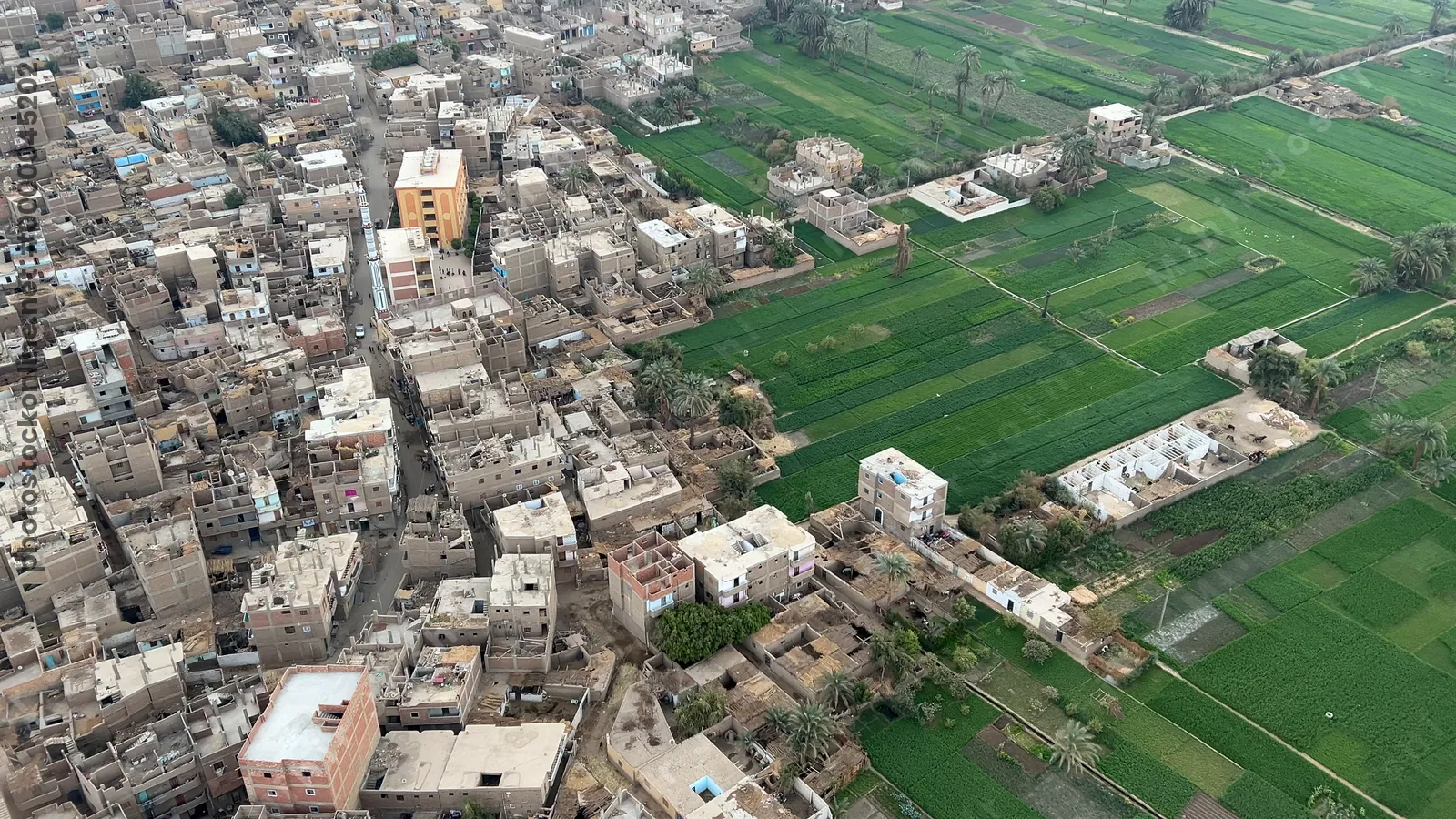 Luxor, Egypt - Feb 10, 2025: Footage from a hot air balloon ride showing Luxor town alongside lush green farmland and fields on the west bank of the Nile in Egypt.
