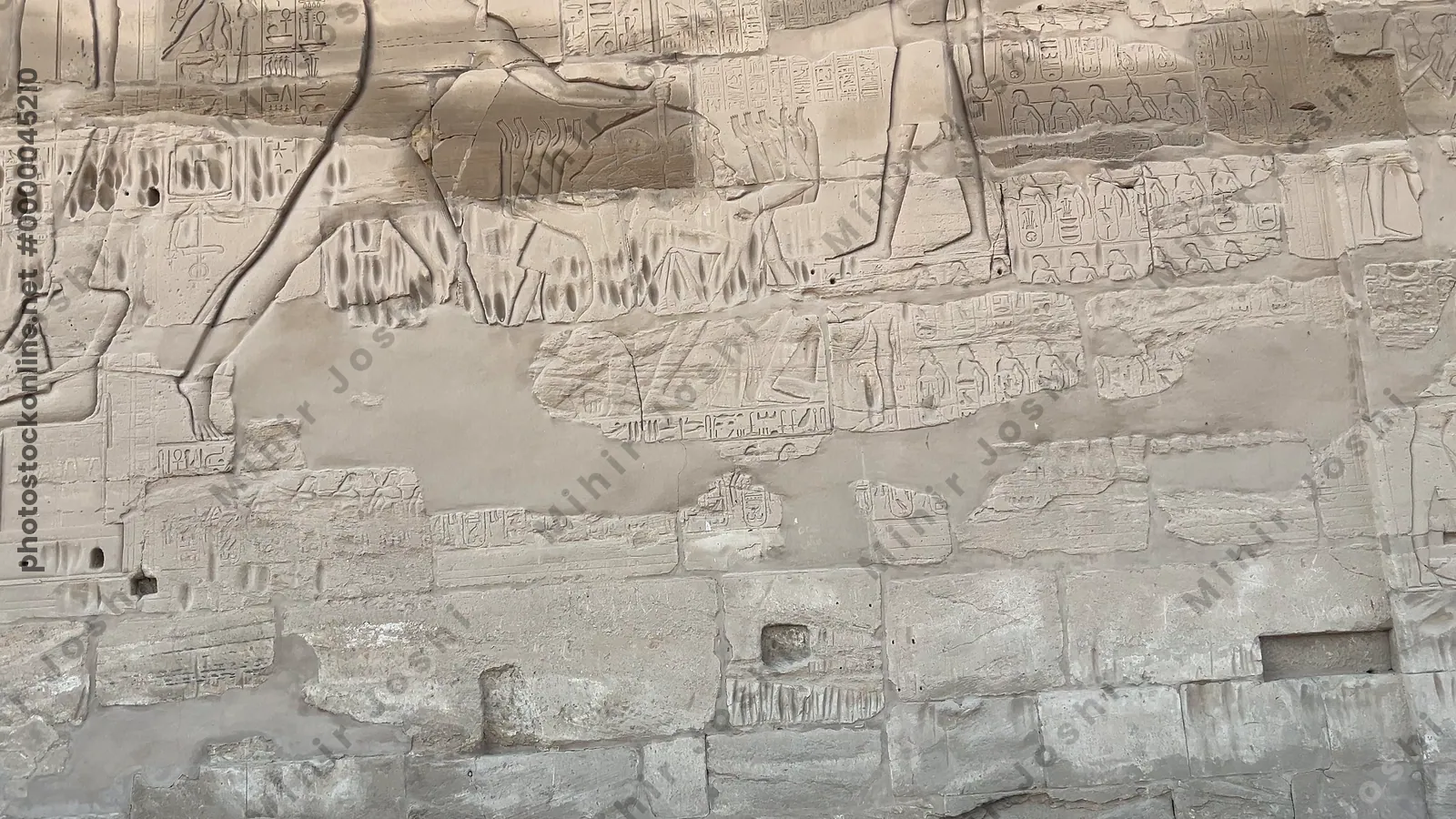 Luxor, Egypt - Feb 10, 2025: Ancient wall relief showing a pharaoh smiting enemies, symbolizing royal power and divine protection, at Karnak Temple in Luxor, Egypt.
