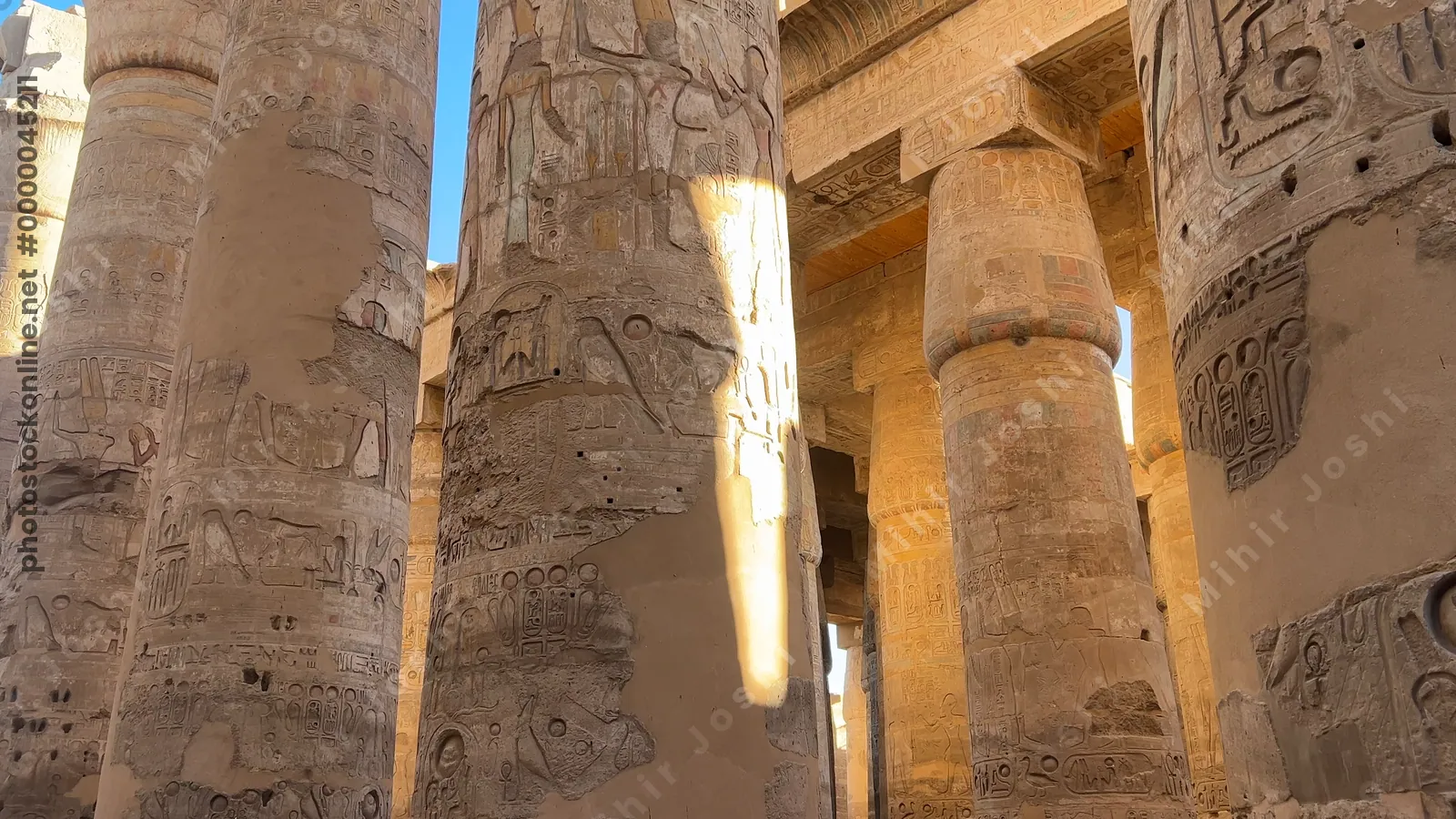 Luxor, Egypt - Feb 10, 2025: Tourists exploring the Hypostyle Hall of Karnak Temple, surrounded by towering sandstone columns decorated with hieroglyphs and relief carvings.
