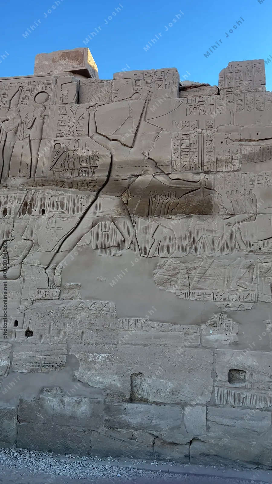 Luxor, Egypt - Feb 10, 2025: Ancient wall relief showing a pharaoh smiting enemies, symbolizing royal power and divine protection, at Karnak Temple in Luxor, Egypt.